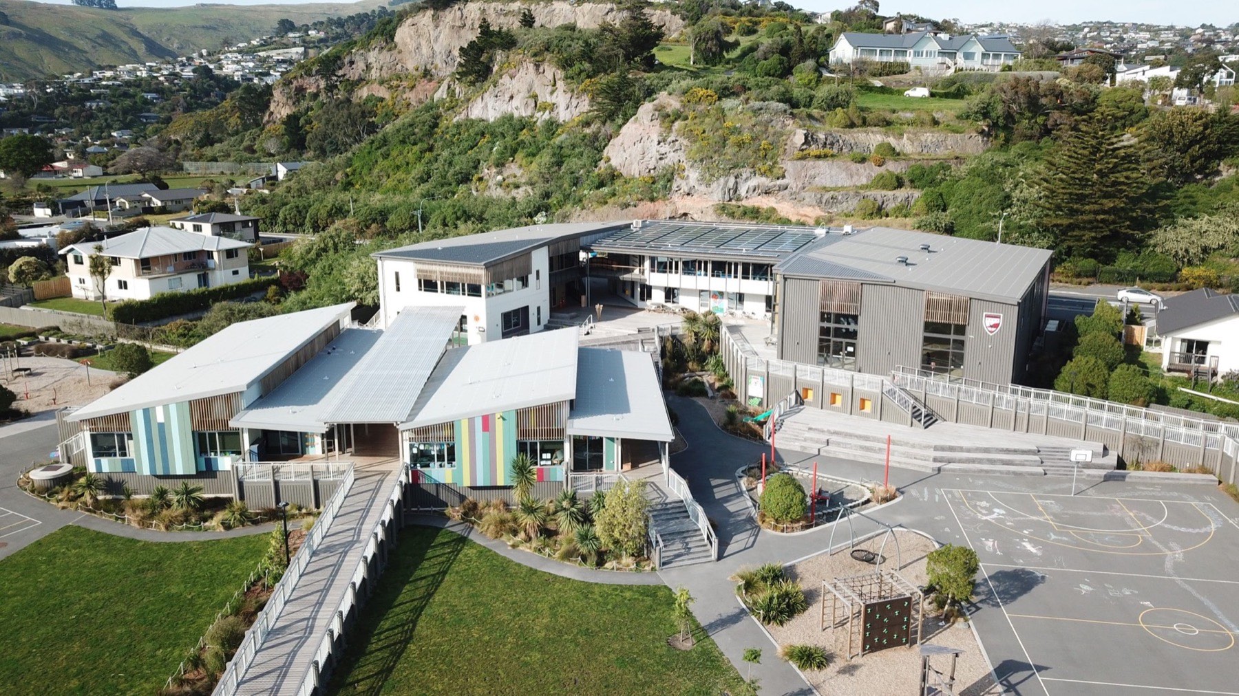 Aerial view of Te Raekura Redcliffs School with colourful cladding and standing seam roofs