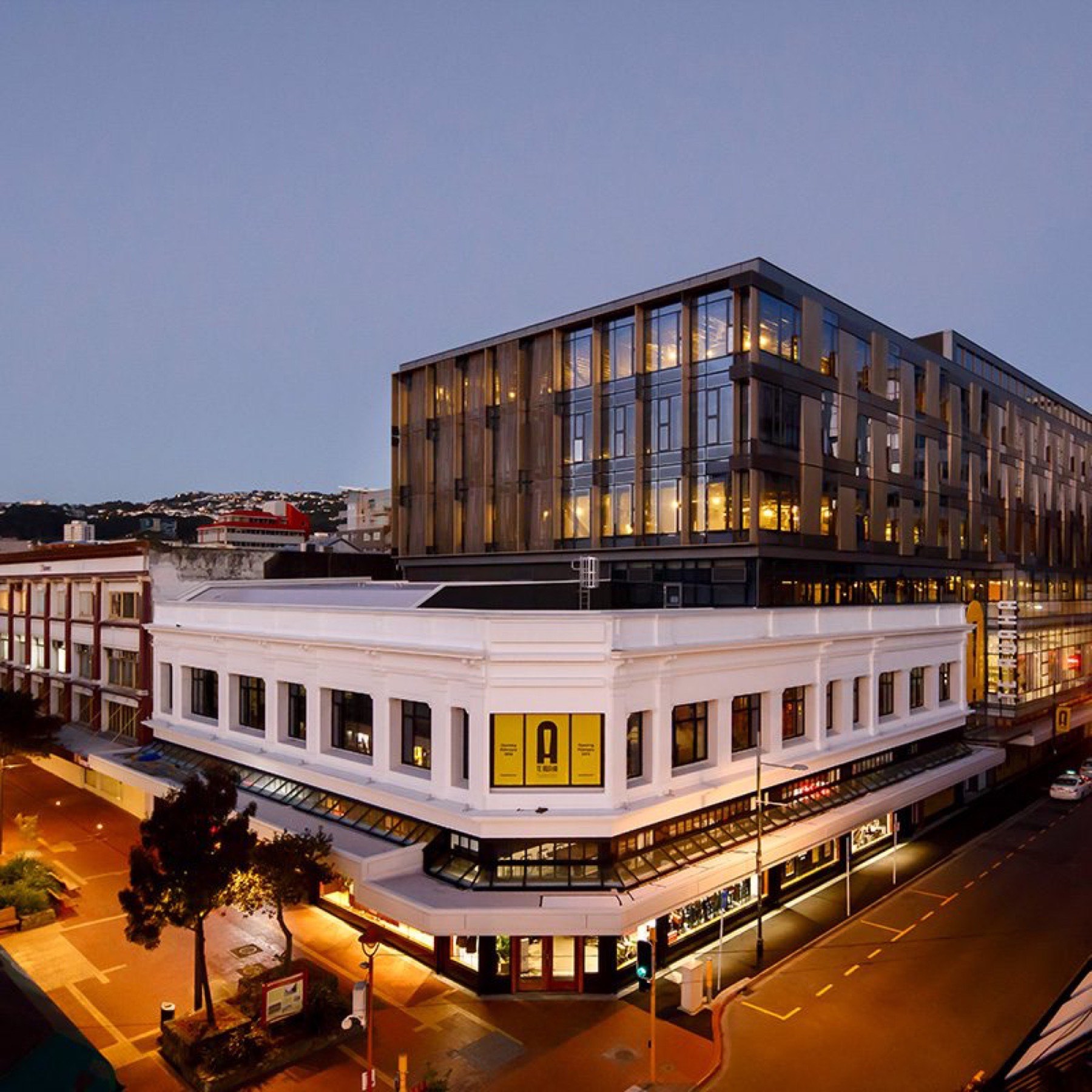 Te Auaha building at dusk with heritage facade and modern glass upper floors